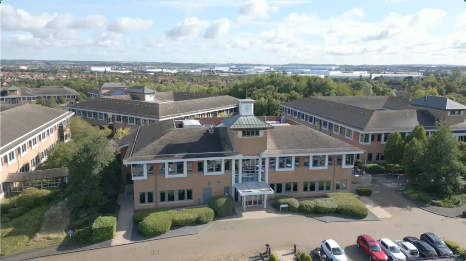 Kents Hill Park. A large complex of square buildings just outside of a city